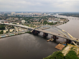 Obraz premium Construction of a bridge across the Dnieper river in Kiev. Aerial drone view.