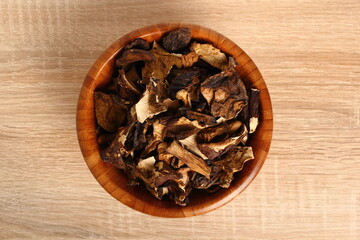 Fototapeta na wymiar Dried mushrooms in wooden bowl. Boletus badius.