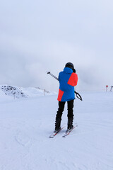 Young skier puts on goggles for better visibility in poor conditions on the piste located on the border between Italy and Austria, Sillian ski resort. Sillian Ski Resort in Hochpustertal Valley, Tirol