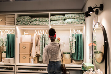 Unrecognizable female black customer choosing goods in shopping mall