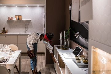 Anonymous black customer choosing kitchen furniture in store during coronavirus pandemic