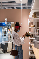 African American customer choosing cloth accessories in shop during quarantine