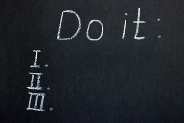 Writing on a chalkboard "do it" with a to-do list. Planning the way forward