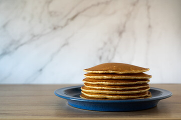 Pancakes on the ble plate on grey background.