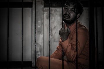 Asian man desperate at the iron prison,prisoner concept,thailand people,Hope to be free,Serious...