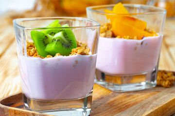 Berry youghurt with granola and fruits in a glass