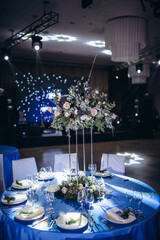Flower decoration of wedding tables.
Banquet table setting and decoration. Cutlery on the table. Blue interior decoration. New Year's decoration.