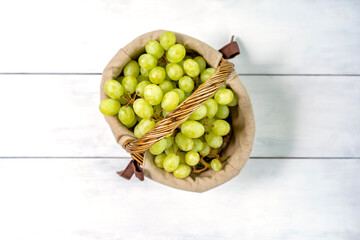 basket with grapes on a white wooden background. view from above