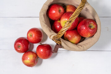 apples in a basket on a white wooden background. view from above