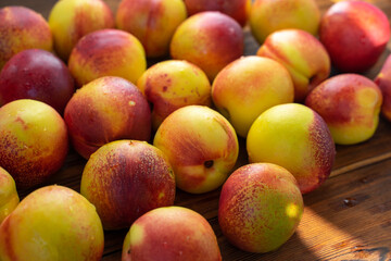 many ripe nectarines on a wooden table. harvest of nectarines