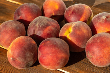 many ripe juicy peaches on a wooden background