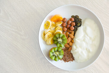 healthy food - breakfast consists of yogurt, nuts, seeds and fresh fruits