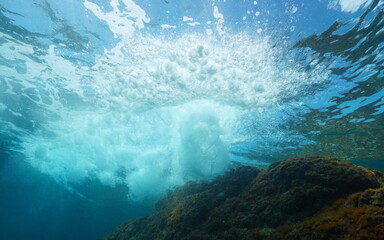 Underwater sea wave breaking on rock below water surface, Mediterranean sea