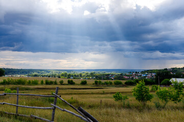 Fototapeta na wymiar Rural summer landscape with green grass, forest on the horizon and cloudy sky. High quality photo