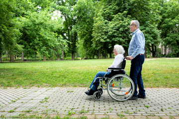 Senior couple rolling and strolling in the park