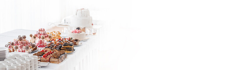 Tisch mit Süßigkeiten auf weißem Banner-Hintergrund mit Platz für Text.