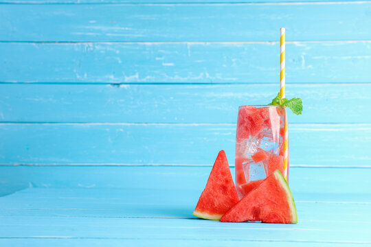 Cold refreshing watermelon juice on old blue wooden table background with copy space.
