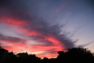 Colorful clouds and city silhouette at sunset