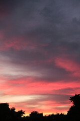 Fototapeta premium Colorful clouds and city silhouette at sunset