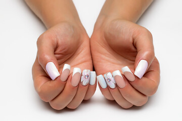 Wedding french white manicure with white painted flower on a white background close-up on long...