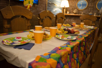 festive table with disposable cups, plates and food