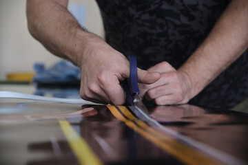 Man cutting print paper with scissors