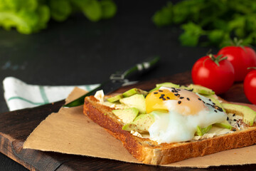 Sandwich with fried egg and avocado pieces