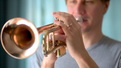 A young man plays the trumpet. Hands of musician. Close up view.