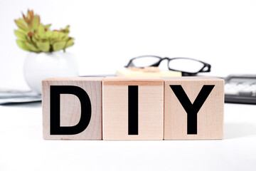 A wooden block with DIY letters on a white background