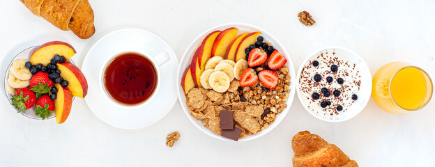Summer breakfast with granola, croissant yoghurt and berries on a light background. Flatly. Banner.