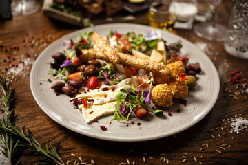 Cheese platter for two: Goat cheese cream, gorgonzola, camembert, grissini and fig jam. Delicious healthy Italian traditional food closeup served for lunch in modern gourmet cuisine restaurant