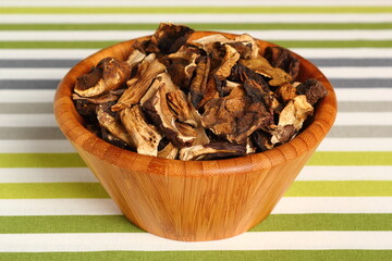 Dried mushrooms in wooden bowl. Boletus badius.