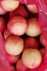 Ripe juicy nectarines in a red bag