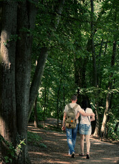 young couple walking in the woods hugging
