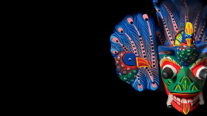 Tribal mask of a mythological character called Naga Raksha from the island of Sri Lanka. made of wood on black background .