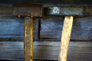 Various hammers and sledgehammers on the wall with wooden handles
