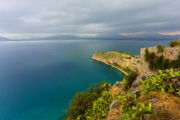 View of the cape, port, the historical part of the city of Nafplion and the island of Bourtzi from the height of the walls of the Themistoklis bastion of Palamidi fortress. Nafplion, Greece