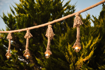 Decorative garden lighting design made with bulbs and thick rope