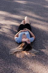 Young woman laying on a countryside road