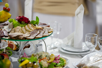 Banquet table with food and dining utensils.