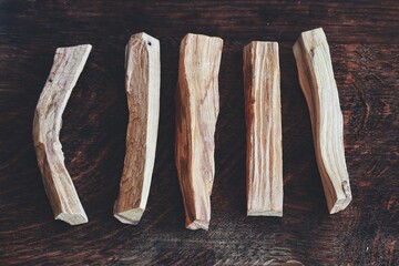 Flat lay of Palo Santo sticks from Bursera graveolens (holy wood) tree laid on dark brown wooden...