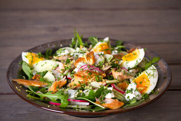 Smocked mackerel fish salad with eggs, arugula and vegetables. horizontal photo