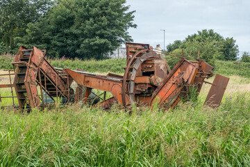 Fototapeta na wymiar Abandoned farming equipment in a field. July 2020