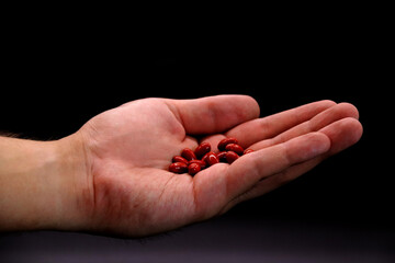 Man's hand is holding red pills,painkillers medical treatment for healthy life