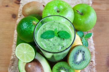 Obraz na płótnie Canvas Green smoothie, fruit and spirulina on jute fabric, healthy food theme, protein shakes
