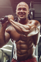 Bodybuilder strong man pumping up triceps muscles