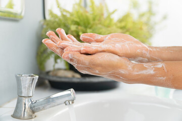 Hands of girl use soap and washing under the water tap. Hygiene concept hand detail. woman washing hands with soap over sink in bathroom.