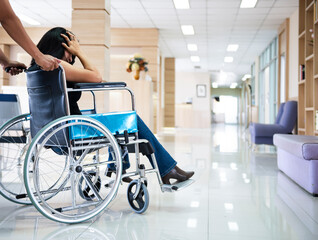 Fototapeta na wymiar Close up asian women on wheelchair at hospital background. female patient serious sitting on wheelchair.