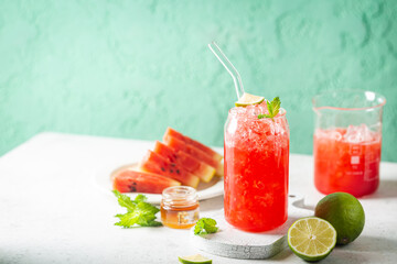 Refreshing cold summer watermelon drink in glasses with slices of watermelon and lime