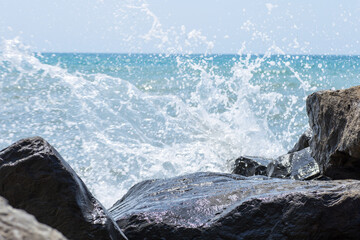 Balance zen stones pyramid on pebble beach with a splashing wave. Stability, balance, and harmony concept